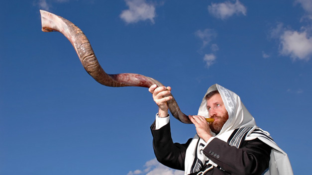 上图：一个犹太人于犹太新年吹响公羊角制成的羊角号（shofar）。犹太人被掳巴比伦回归以后，吹角节成为犹太人的农历新年（Rosh Hashanah），这一天要一百次吹响羊角号。