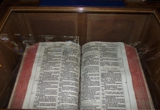 上图：莎士比亚生前使用的1611年KJV英王钦定本圣经，收藏在圣三一教堂（Church of the Holy Trinity, Stratford-upon-Avon）内莎士比亚墓的旁边，特地被打开在诗篇四十六篇。在KJV圣经中，诗篇四十六篇的第46个单词是「战抖 Shake」（诗四十六3），倒数第46个单词是「枪 Spear」（诗四十六9，古英语拼作Speare），合起来正好是莎士比亚的名字ShakeSpeare。此外，KJV圣经于1610年完成翻译，当时莎士比亚正好46岁。因此，有人认为莎士比亚参与了诗篇四十六篇的KJV版翻译。