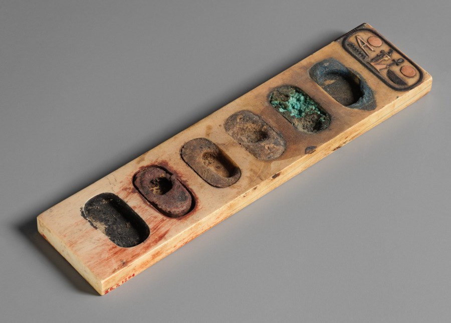 上图：主前1390-1352年的埃及调色板。这个调色板用一块象牙雕刻而成，有六个椭圆孔盛颜料，包括蓝色、绿色、棕色 、黄色、红色和黑色。一端的椭圆象形茧纹章（Cartouche）刻有法老阿蒙霍特普三世（Amenhotep III）的名字。古代文士所携带的墨盒就是一种调色板，板上有放笔的空档和装墨的凹陷处。笔用灯心草或苇杆削尖制成，墨用碳和树胶调和制作。红墨则加上氧化铁制成，用来书写标题或绘制书卷上的线条。此外，写字工具还包括削笔的刀子（耶三十六23）。