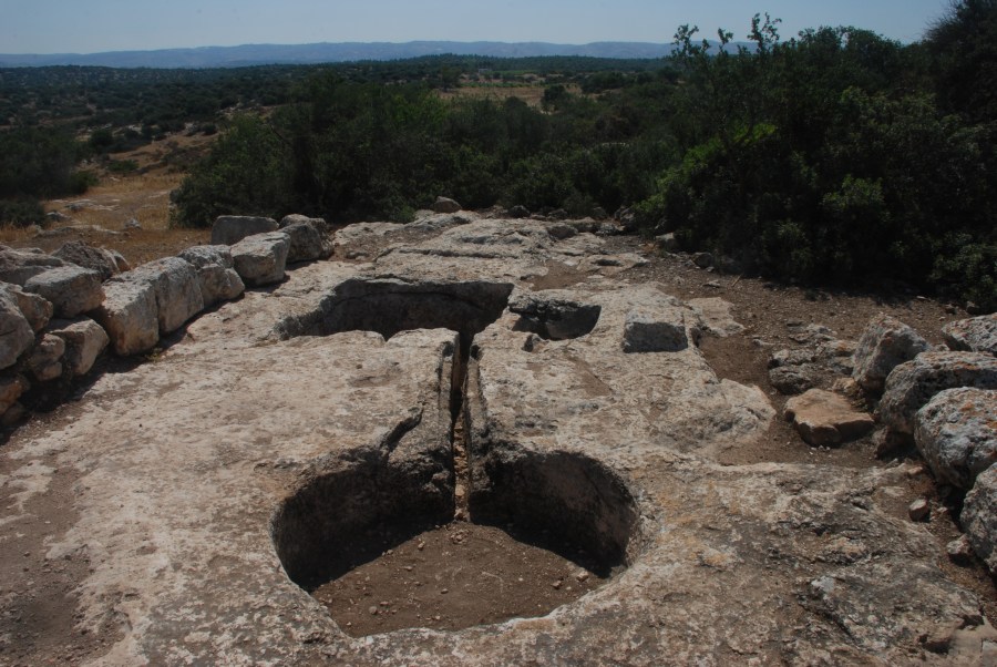 上图:以色列的古代压酒池遗迹。酒醡分上下两层酒池,中间有一条通管相连。酒池可能是一块凿空的石头,也可能用砖石砌成。葡萄放在位置稍高的上层酒池中,工人用脚踹葡萄,汁液透过通管流到下层的酒池中。