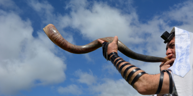 上图：一位犹太人在犹太新年吹角节（Rosh Hashanah）吹响羊角。「祂从祸坑里，从淤泥中，把我拉上来，使我的脚立在磐石上，使我脚步稳当」（诗四十2），是犹太人在吹角节期间的Amidah祷告词中的一部分。